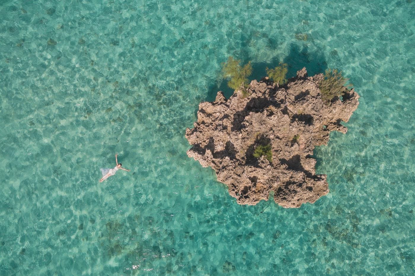 Aerial swimmer turquoise sea rocky reef mauritius