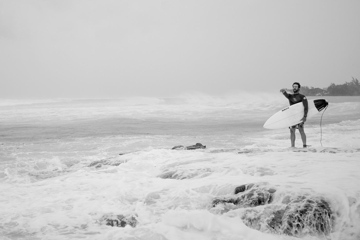 Black and white surfer walking ocean shore mauritius