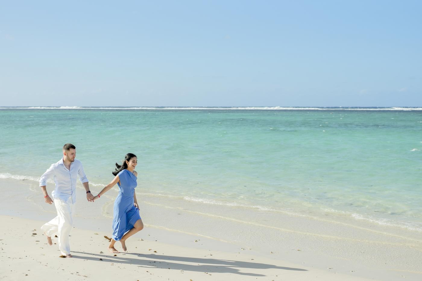 Couple holding hands walking on beach mauritius