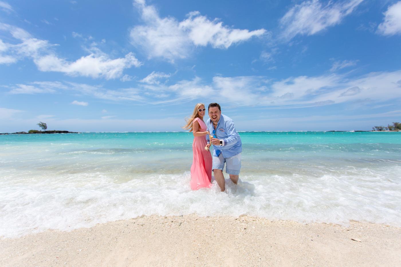 Couple playing in shallow beach waves mauritius