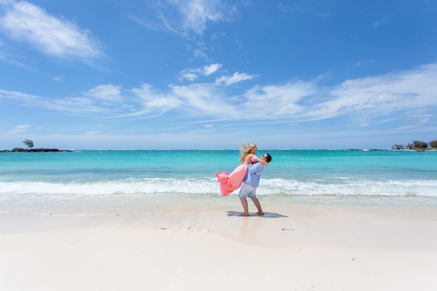 Playful couple lift tropical beach mauritius