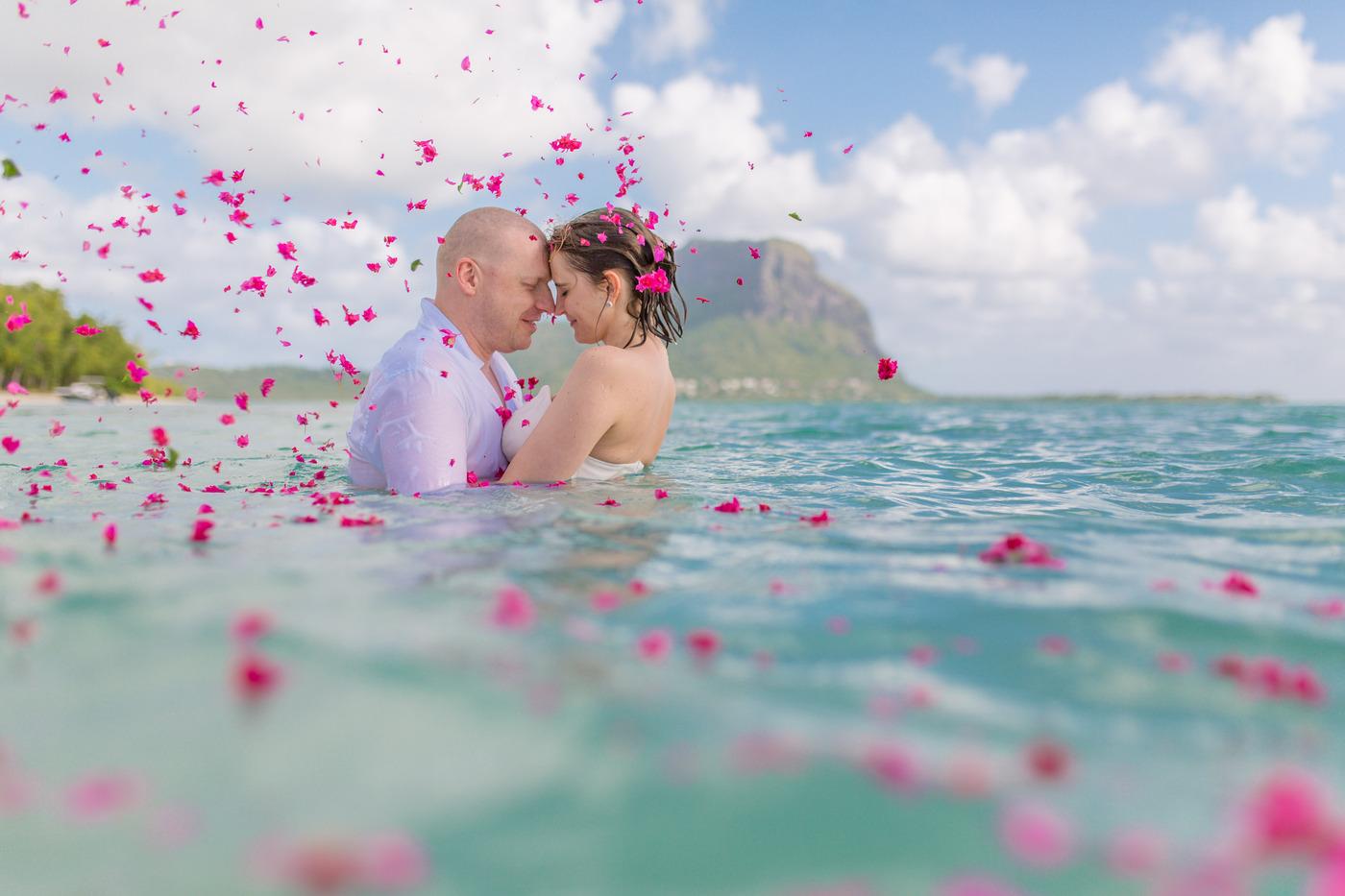 Romantic couple pink petals shallow water mauritius