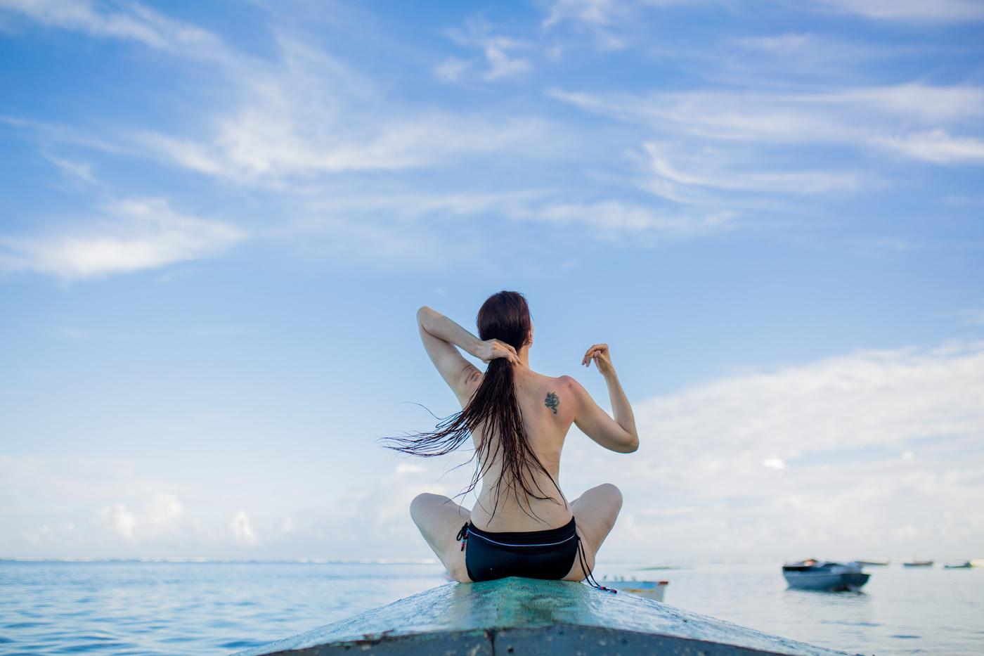 Woman sitting on boat looking out to sea mauritius