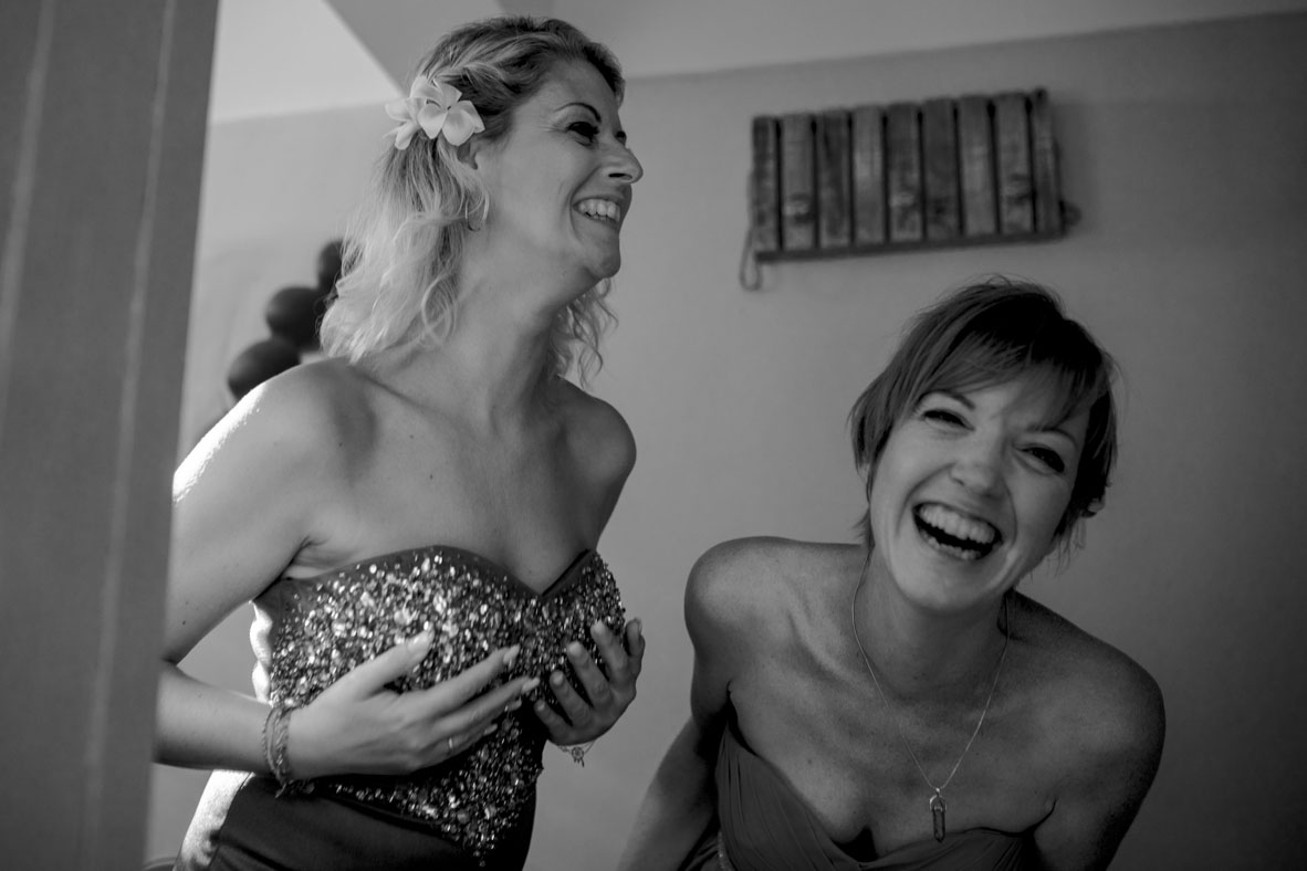 Bride and bridesmaid laughing while getting ready in Mauritius